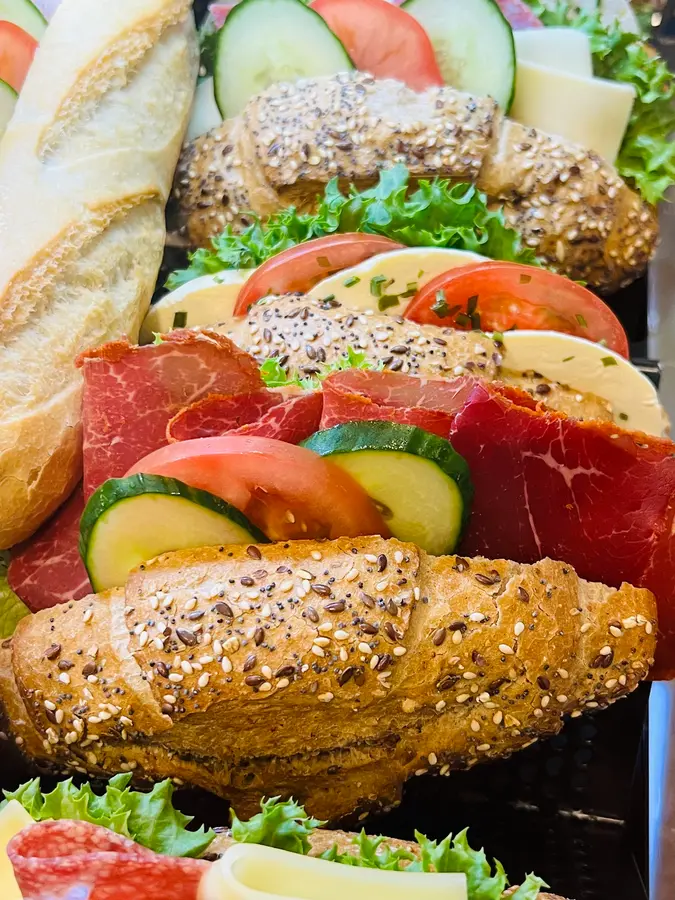 Frisch belegte Körnerbrötchen und Baguettes mit Tomate, Gurke, Käse und Salat
